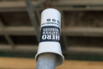 Naklejka premium discarded Hero Certified Burgers restaurant chain beverage cup on a defocused industry background, Toronto