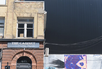 Naklejka premium exterior building facade and sign of The Cabinet Salon, a hair salon, located at 577 Queen St W (entrance on Portland), Toronto