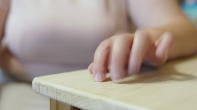 Hand of caucasian woman tapping fingers on table closeup. Drumming fingers with tap on surface during nervous waiting or thinking.