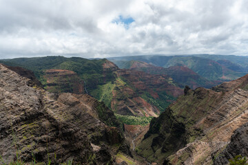 Fototapeta premium A breathtaking view of the lush valley and mountains under a cloudy sky