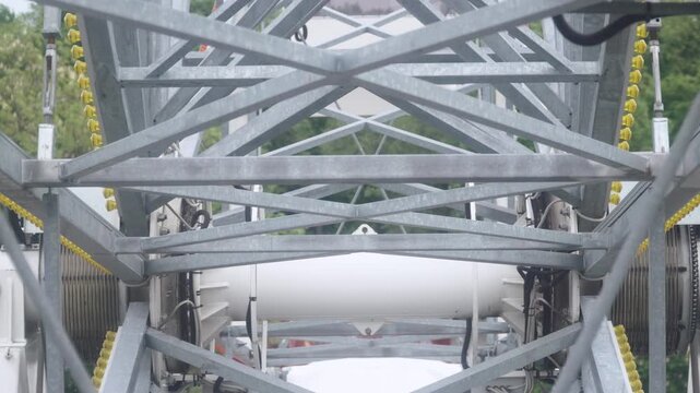 Rigid steel framework and support towers during movement of Ferris wheel. Close up of cross bracing beams and truss system creating strong structural construction of popular observation attraction.