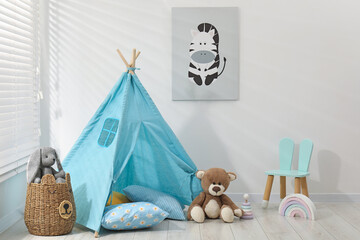 Wigwam, toys, small chair and pillows near white wall in child's room © New Africa