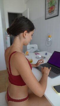 Woman focused on coding at her home workstation with headphones