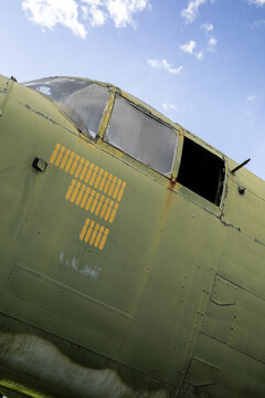 Low-angle photograph of a vintage airplane cockpit emphasizing the aircraft structure and historical aviation design.
