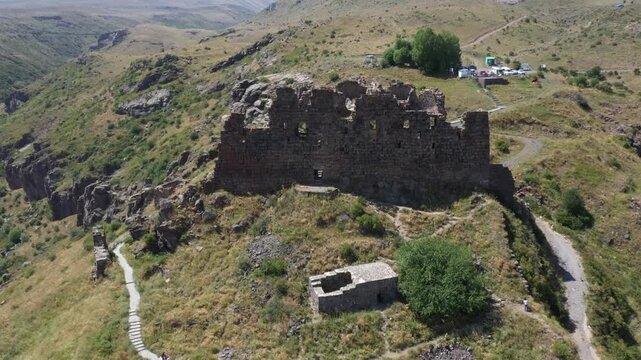 Aerial view of the historic medieval Amberd Fortress in Armenia on a sunny summer day under a blue sky. Spring scene, shot with a drone