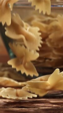 Farfale pasta falls on a wooden table. Filmed on a high-speed camera at 1000 fps. High quality FullHD footage