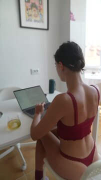 Focused female student engaged in notetaking at kitchen table