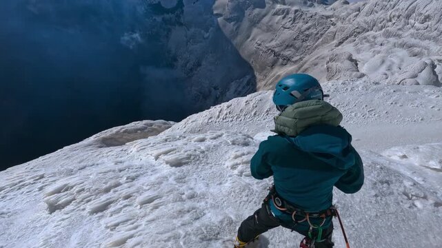 Point of view of a mountaineer rappelling down an icy crevasse on a high altitude glacier