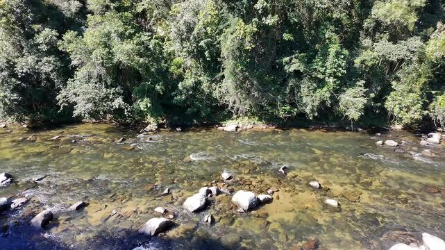 Aerial view of the Maca&eacute; River rapids, Encontro dos Rios, Lumiar, Nova Friburgo &ndash; Aerial lateral drone tracking shot descending the Maca&eacute; River in a region of strong currents and Atlantic Forest.