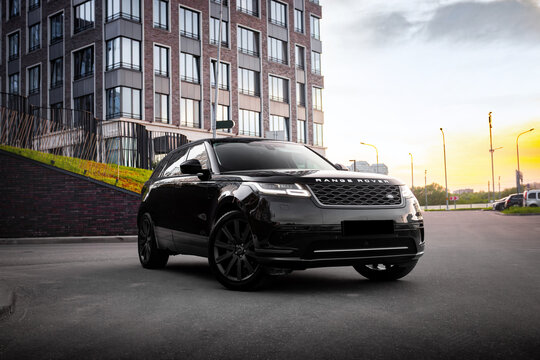Black Range Rover Velar in urban city setting near modern buildings. Luxury SUV with elegant styling, premium design, and contemporary atmosphere. Concept of prestige, comfort, and luxury lifestyle.