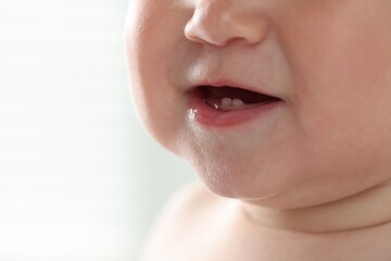 Fototapeta premium Cute child with first baby teeth indoors, closeup. Space for text