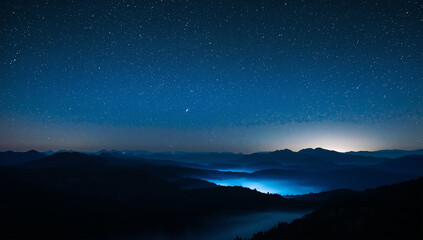 Fototapeta premium 星空と天の川の下で青い霧に沈む山脈の幻想的な夜景写真