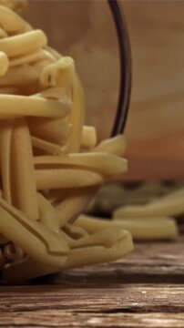 Dry pasta falls on a wooden table. Filmed on a high-speed camera at 1000 fps. High quality FullHD footage