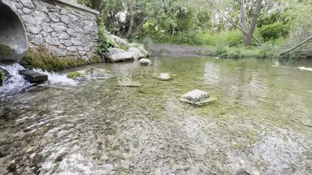 Creek emerging from stone pipe panning