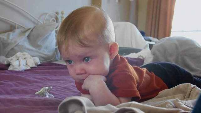 Infant girl lying on bed, smiling and playing at home. Early childhood development and joyful exploration concept