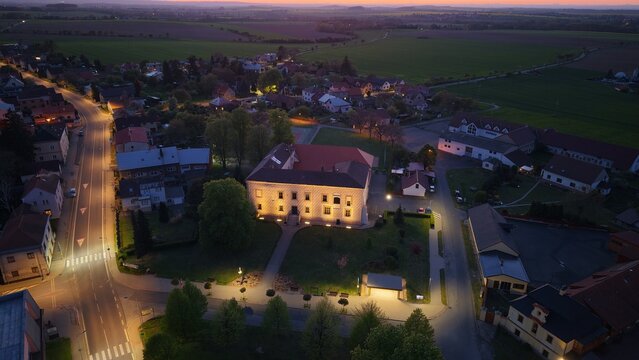 Illuminated Renaissance Suchdol Castle with decorative sgraffito facade aerial panorama at dusk