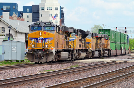 A quartet of locomotives lead a Union Pacific Railroad intermodal freight train westbound through a suburban Chicago community.