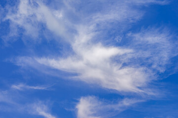 Fototapeta premium Cirrus fibratus and uncinus cloud formations in upper troposphere displaying ice crystal structures and wind shear patterns