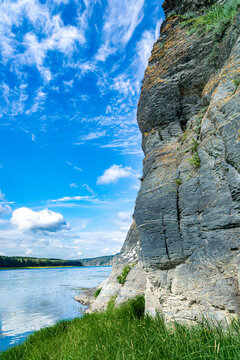 Devonian-Carboniferous limestone cliff exposing 360-million-year-old sedimentary stratification with orange lichen colonization