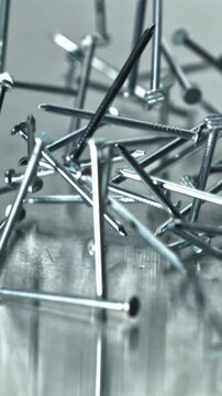 Closeup pile of nails on reflective surface, sharp heads and scattered Filmed on a high-speed camera at 1000 fps.