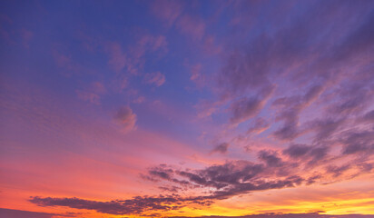 Fototapeta premium Stunning Vibrant Sunset Sky with Colorful Clouds,A breathtaking view of a dramatic sunset sky filled with vibrant shades of orange, pink, purple, and blue. Soft, scattered clouds are illuminated.