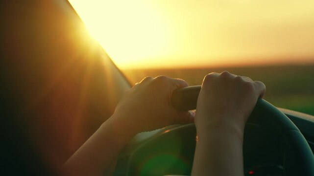 Female hands holding steering wheel of car, Close-up . Woman traveler driver driving car. Free young woman traveling by car. Weekend, car, adventure, road, sports. Countryside trip. People traveling.