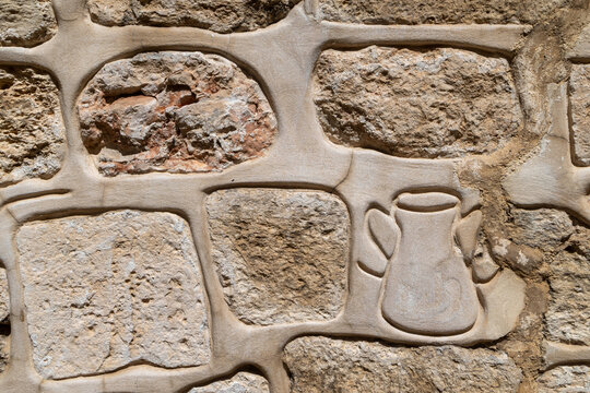Jerusalem, Israel, close up texture of ancient stone wall masonry with decorative carved jug element on facade.