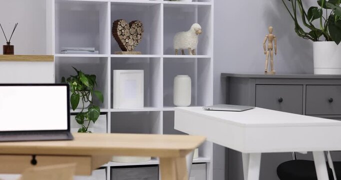 Interior design. Desks with laptops, other furniture and decor. Camera moving right