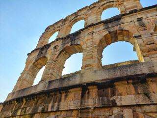 Obraz premium Detail of ancient stone arches in Roman style under a clear blue sky