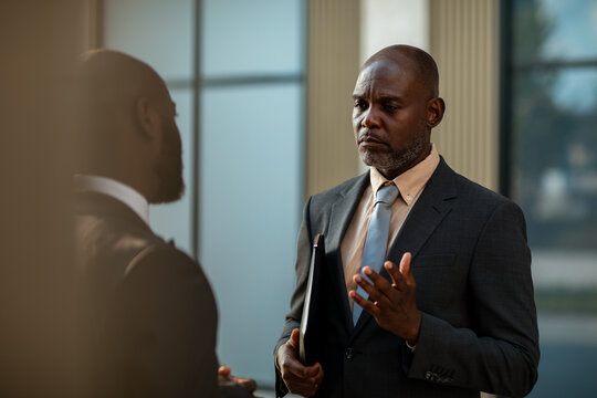 Businessmen discussing strategy in office lobby