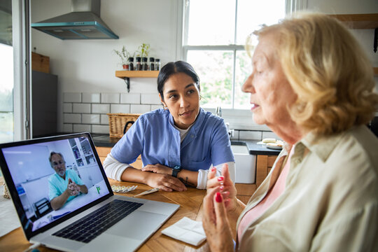 Nurse and senior woman in home telemedicine video consultation