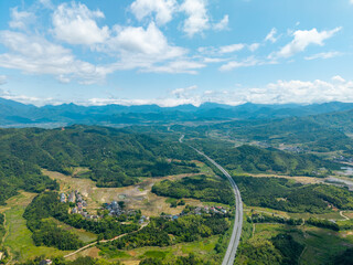 Fototapeta premium A high angle aerial view of the lush green mountains and winding roads in Wuyi Mountain in Fujian China