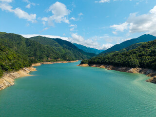 Obraz premium A scenic view of a blue river flowing between lush green mountains in Wuyi Mountain located in Fujian China