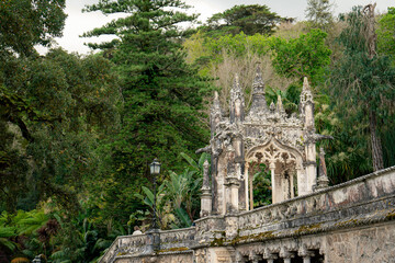 Fototapeta premium Intricate Stone Archway and Balustrade in a Lush Green Garden Environment. Quinta da Regaleira, Sintra, Portugal