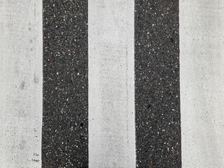 Fototapeta premium Crosswalk stripes contrast sharply against asphalt surface