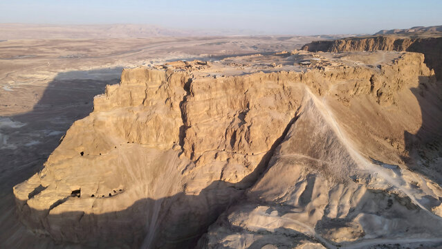 Masada ancient fortress ruins on rocky plateau at sunset