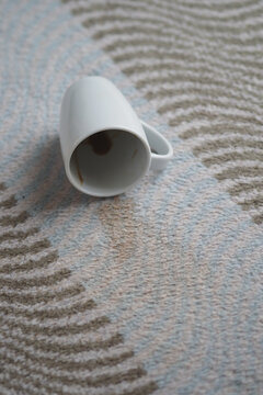Coffee cup lies on the floor with dark stain around it