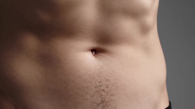 Man suffering from severe acid reflux and stomach pain showing close up of bare abdominal torso area for medical concept