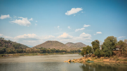 Obraz premium Calm River Valley with Boats and Hills in Laos Countryside