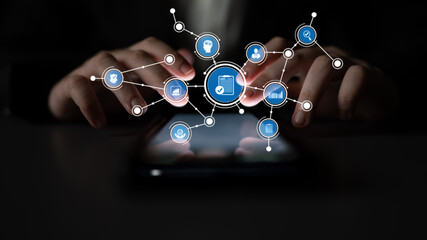 A smartphone sits in dim lighting surrounded by digital icons, representing technology, data management, and modern networking trends in business settings. Tessel © InfiniteFlow