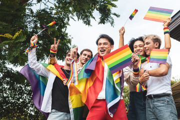 Fototapeta premium Pride month. Friends from IGBTQ, men, women, lesbians, and transgender people of various nationalities joined the parade in park, carrying signs and flags celebrating equal rights at Pride Festival. 