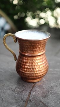 Traditional Ayran Drink in a Hammered Copper Mug Outdoors
