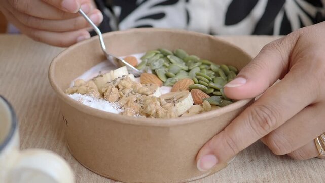 Healthy breakfast bowl preparation in a cafe setting