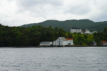 Obraz premium Fishing industry warehouses line the shore of the Storfjorden near Alesund in Norway