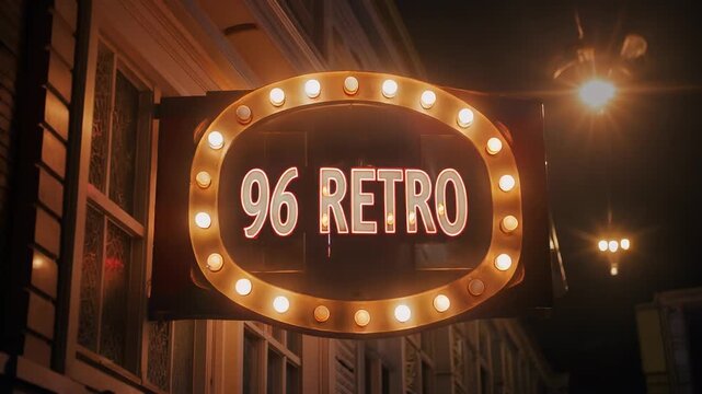 Vintage oval marquee sign displaying 96 Retro text with glowing incandescent theater light bulbs on an urban building exterior at night with warm street lighting and bokeh.
