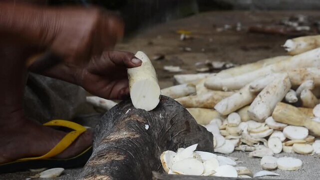 A young woman preparing cassava as the main ingredient for traditional food in a home kitchen.
