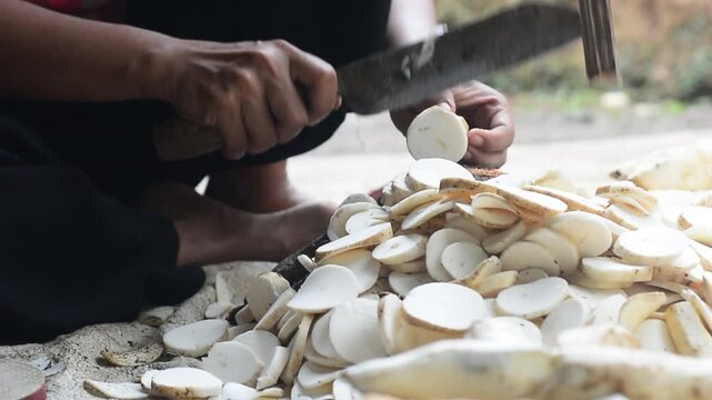 A young woman preparing cassava as the main ingredient for traditional food in a home kitchen.