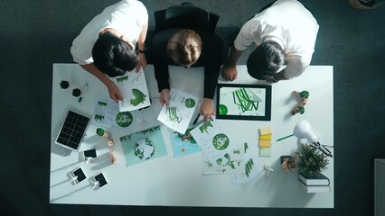 Top down view of business team discussing about renewable energy. Aerial view of skilled diverse business people working together to plan about zero waste while using laptop on table. Alimentation.