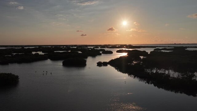 Aerial view of Yucalpeten lagoon with mangrove islands and golden sun reflections on the water at sunset in Progreso, Yucatan, Mexico.