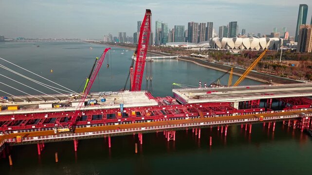 Aerial view of cranes and construction equipment are working to dismantle an old cable stayed bridge.